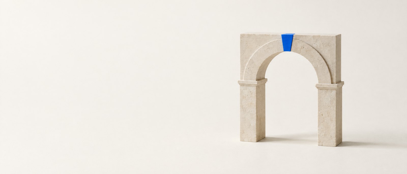 Limestone arch model with a blue keystone — studio still life