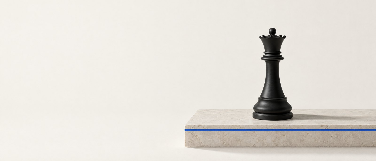 Black chess queen on a limestone slab with a blue inlay — studio still life